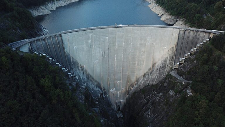 "Iconic Contra Dam, featured in the movie GoldenEye, towering over the Verzasca River in Switzerland
