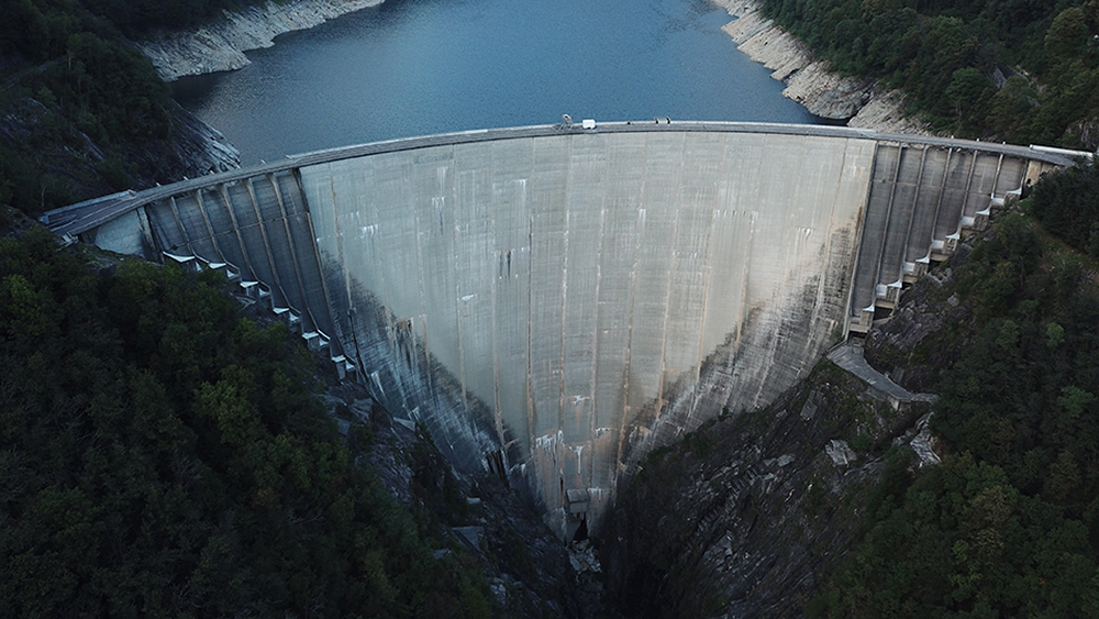 "Iconic Contra Dam, featured in the movie GoldenEye, towering over the Verzasca River in Switzerland