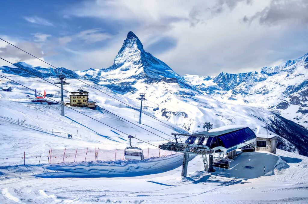 Zermatt Ski Resort surrounded by majestic snow-capped peaks, offering premier slopes and stunning alpine views